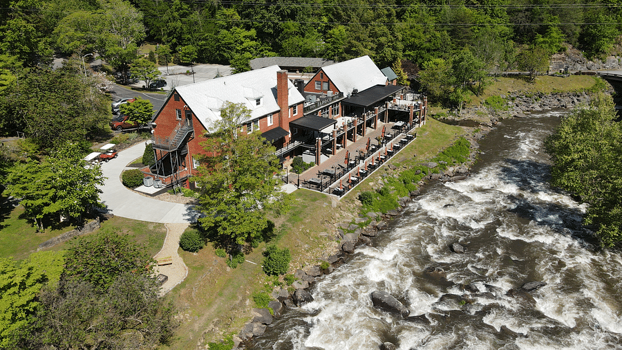 bird eye view of our resort with a river stream flowing in front of it tucked in lush greenery - Historic Tapoco Lodge