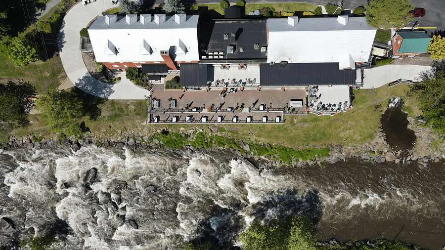 top view shot of our resort with white colored rooftop facing towards the flowing river in front of it - Historic Tapoco Lodge