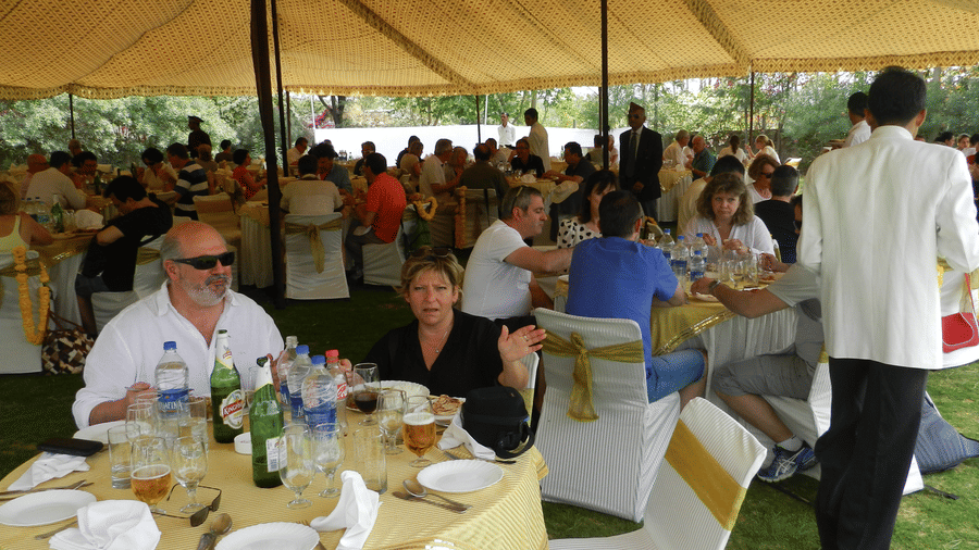 A lively outdoor gathering under a tent, where guests dine and chat in a festive atmosphere - Khas Bagh, Jaipur.