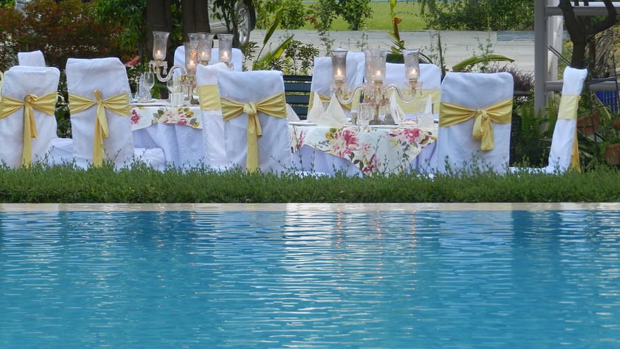Elegant outdoor dining by the pool, with white and gold-decked tables set for a special event - Khas Bagh, Jaipur.