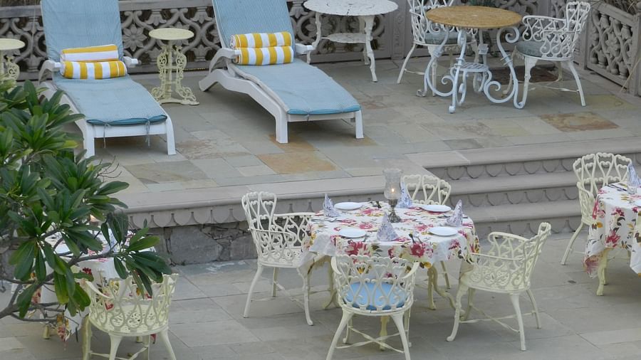 A cosy outdoor seating arrangement with floral cushions and vintage-style furniture - Khas Bagh, Jaipur.