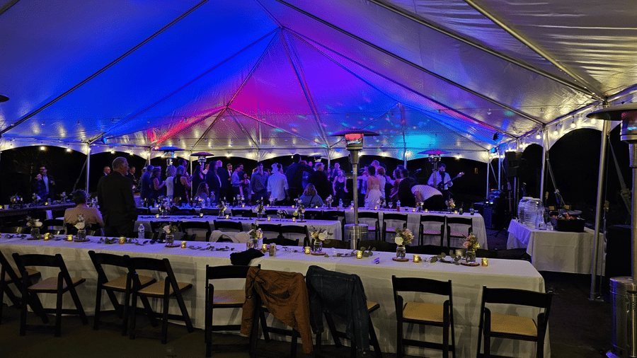 A tented evening reception at Kit Carson Lodge featuring long dining tables, warm lighting, and guests enjoying dinner