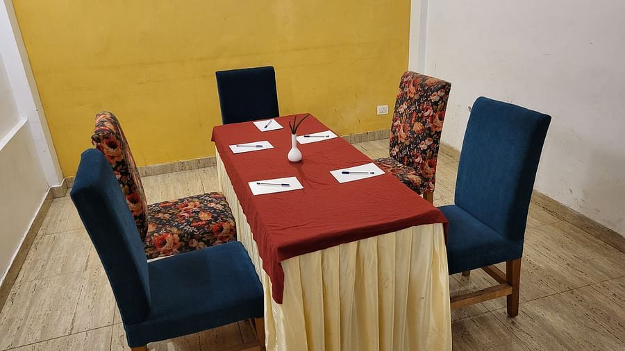 Side angle of the meeting space with a yellow accent wall and neatly arranged chairs at Dagshai Manor Kasauli - Inde Hotels.