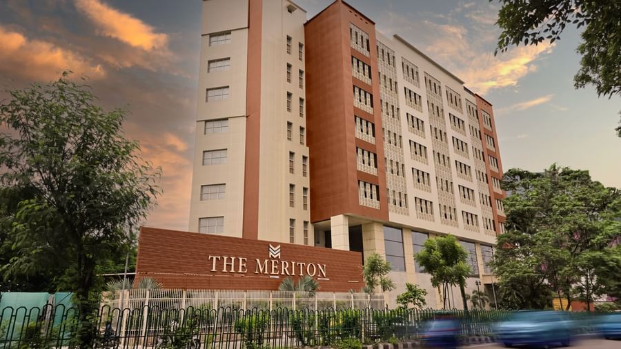 The exterior of The Meriton during the early evening with a road in front of it featuring a beautiful evening sky in the background.