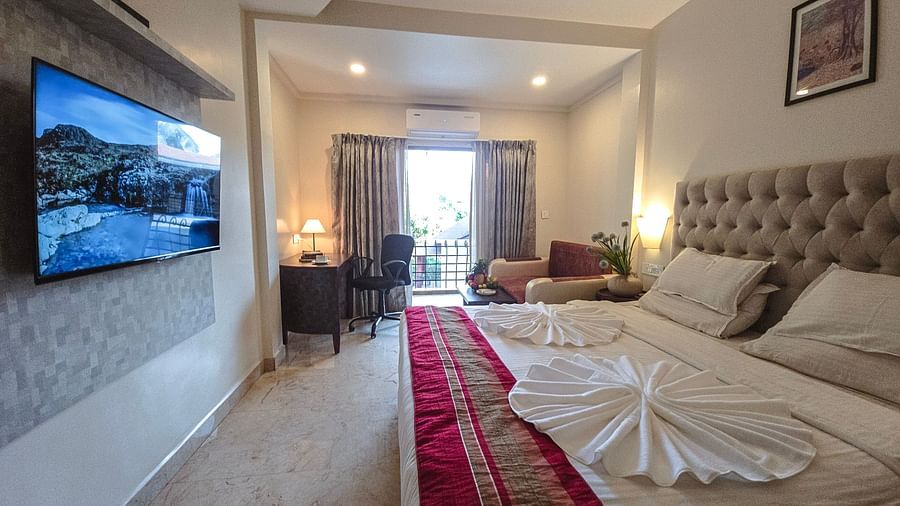 A bright room with an elegant bed, seating area, and access to a balcony – The Verda de Miranda Resort.
