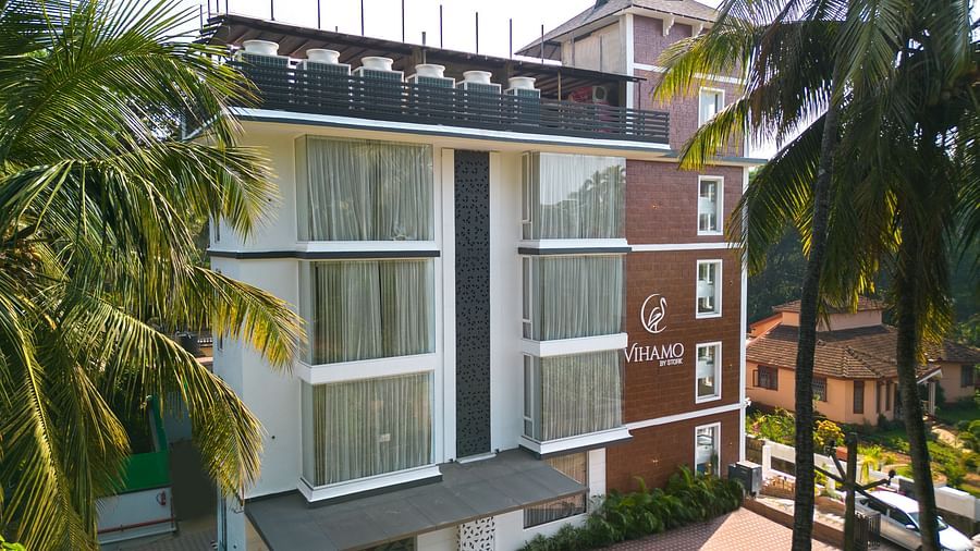 Facade of the hotel with 2 coconut trees in the front | Renest Calangute, Goa