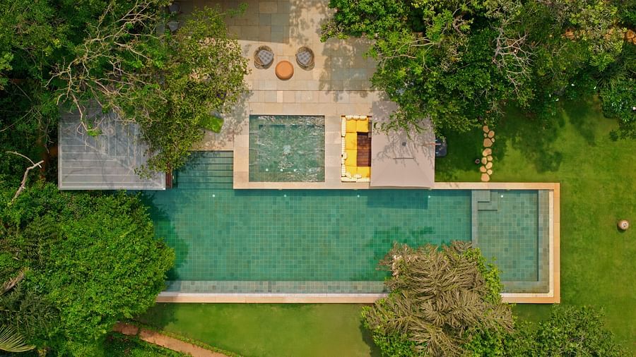 An aerial shot of the stunning green-tiled pool area at Villa Moira by V Escapes, surrounded by manicured lawns and trees.