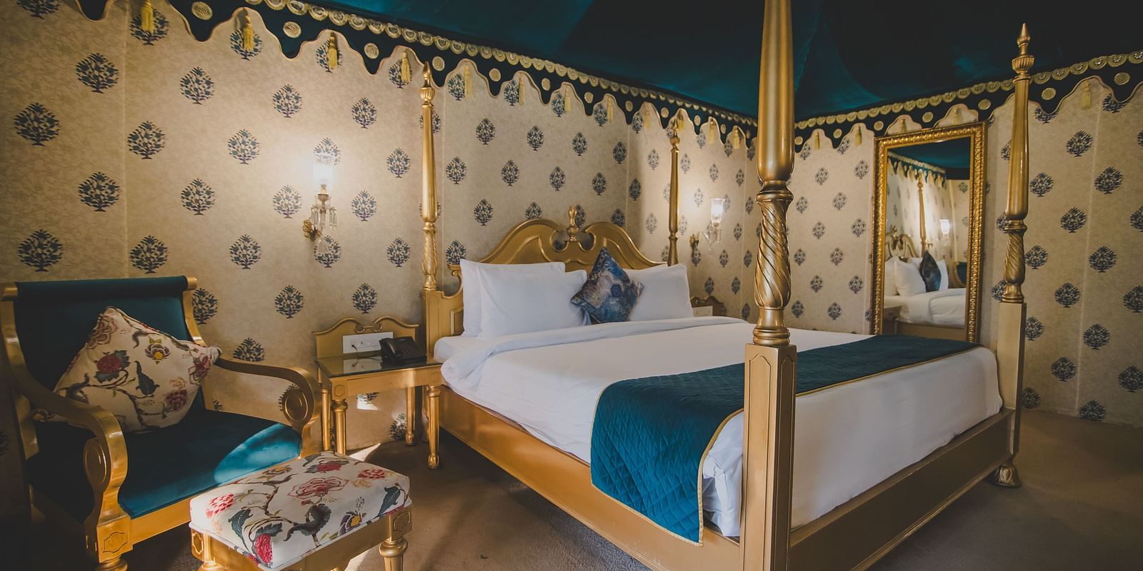 Royal Luxury Tent with Balcony with a bed and a sofa with table on the side at Rajasthali Resort and Spa.