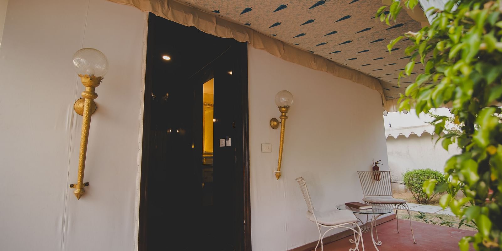 Facade of an accommodation with fancy lights mounted on the sides of the door at Rajasthali Resort & Spa Jaipur.