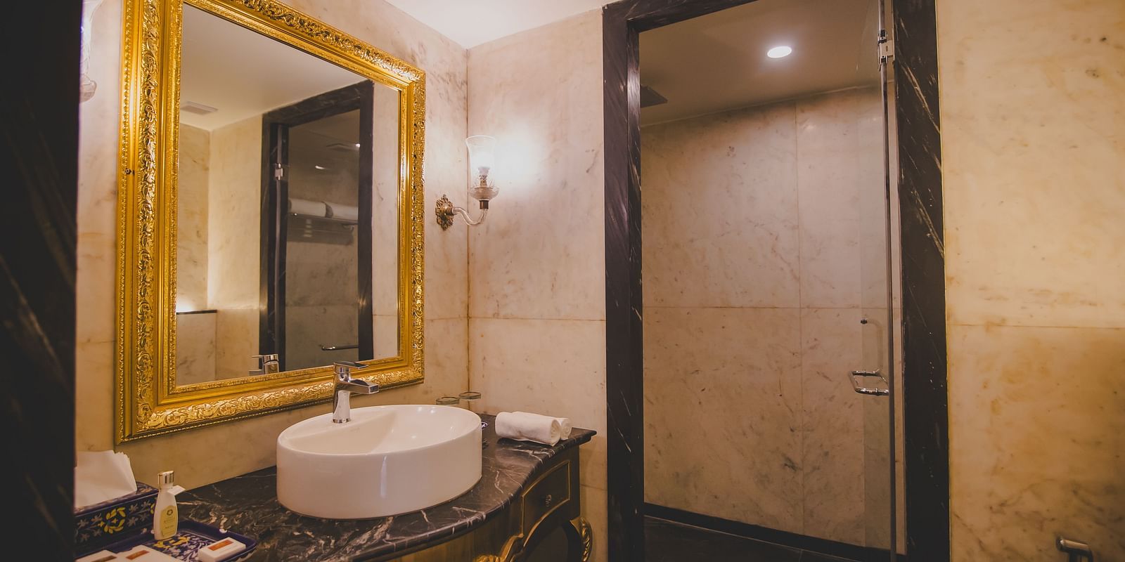 Image of a washroom with a mirror and a sink below it at Rajasthali Resort & Spa Jaipur..