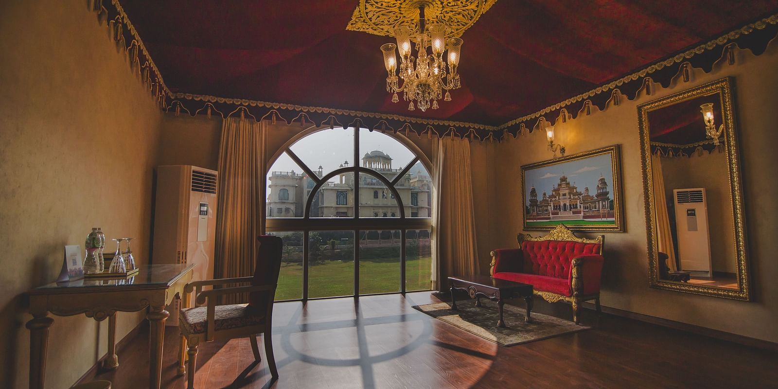 Image of a room with a large window and a sofa in the corner at Rajasthali Resort & Spa Jaipur.