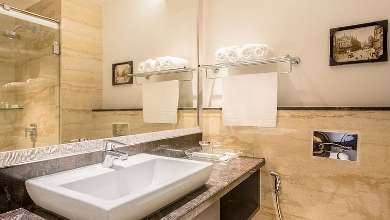 A modern bathroom with a large mirror, white sink and shower - TGI Grand Fortuna, Hosur
