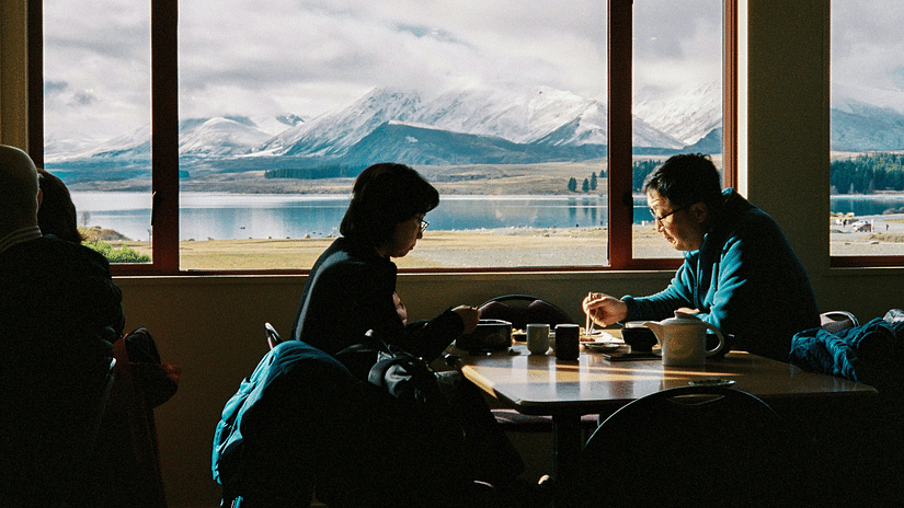 People enjoying a meal with a mountain view.