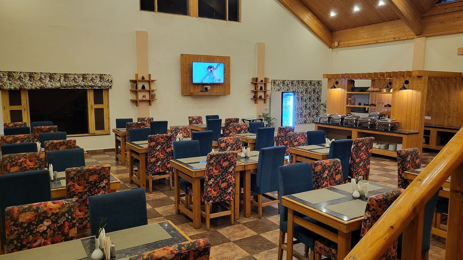 A closer view of the dining space with wooden furniture, ambient lighting, and a cosy setting at Dagshai Manor Kasauli - Inde Hotels.
