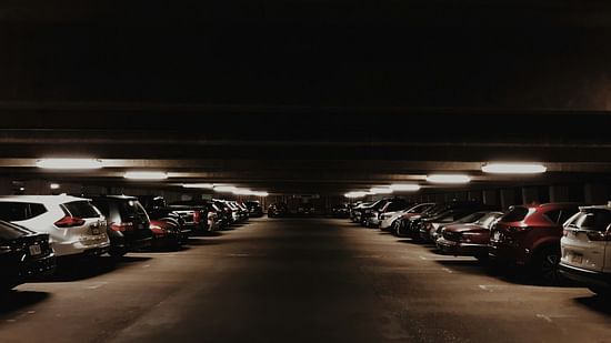 Dimly lit underground parking lot with rows of parked cars