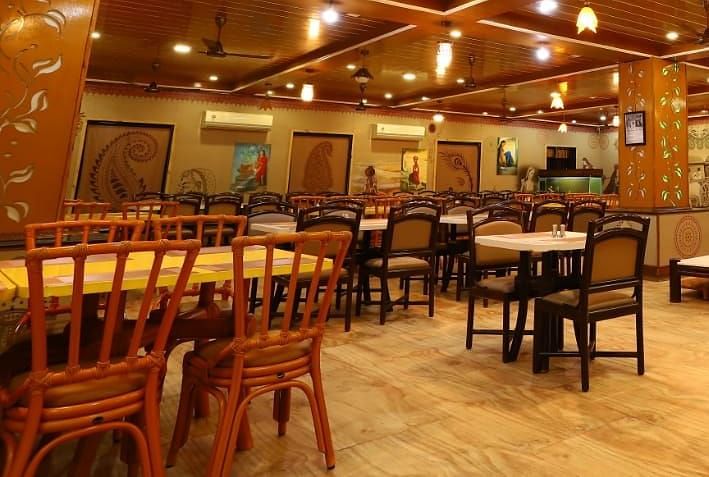 Restaurants fully furnished with wooden tables and chairs with warm lighting.