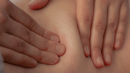 Close-up view of a therapist performing a gentle back massage using smooth hand techniques at Kavya Himalayas spa.