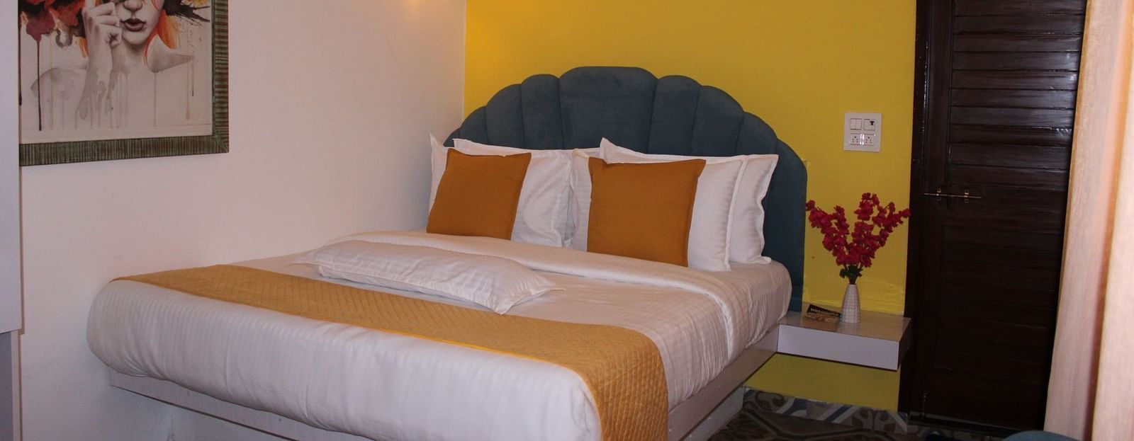 A large sized mattress with two cushions along with floral decorations,  wall painting and decorative lights - Royale Amata