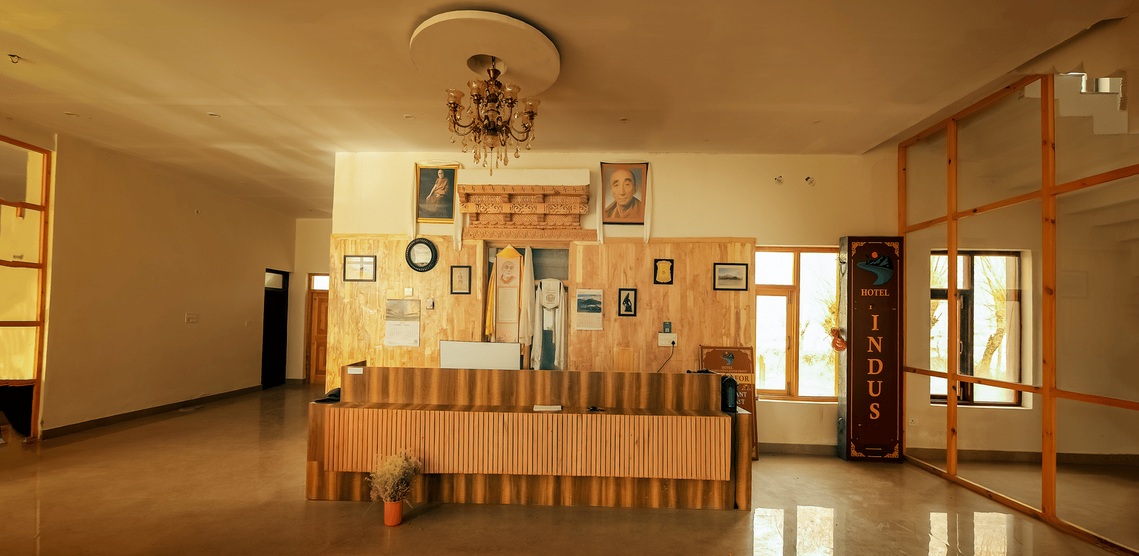 A wide interior view of the wooden reception desk and spacious lobby at Indus Serenity Retreat.