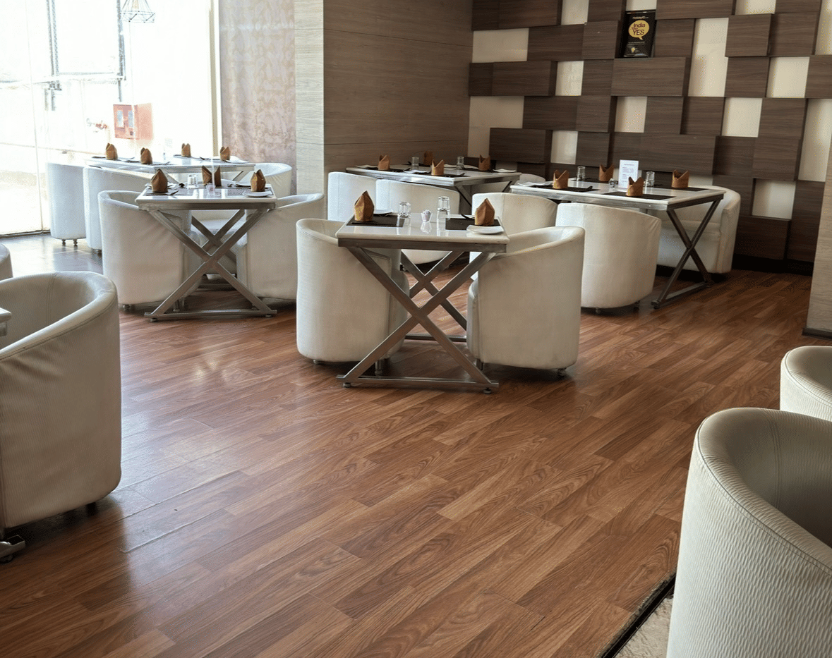 An elegant dining area at Cenneys Gateway with wooden flooring, neatly arranged chairs and tables and contemporary decor.