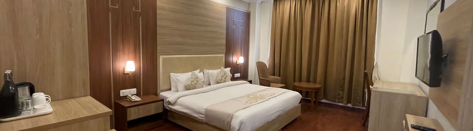 Overview of the Premium Room with a queen bed, tea and coffee maker and a tv wallmounted - Sumitel Gangtok