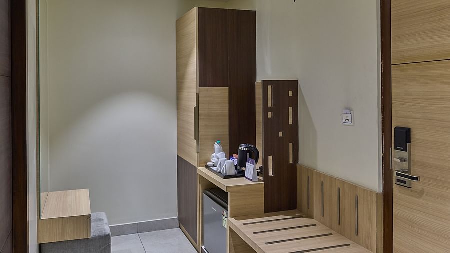 Wardrobe, fridge and seating area in the deluxe room at Grand Continent - A Sarovar Premiere Affiliate Hotel, Hosur