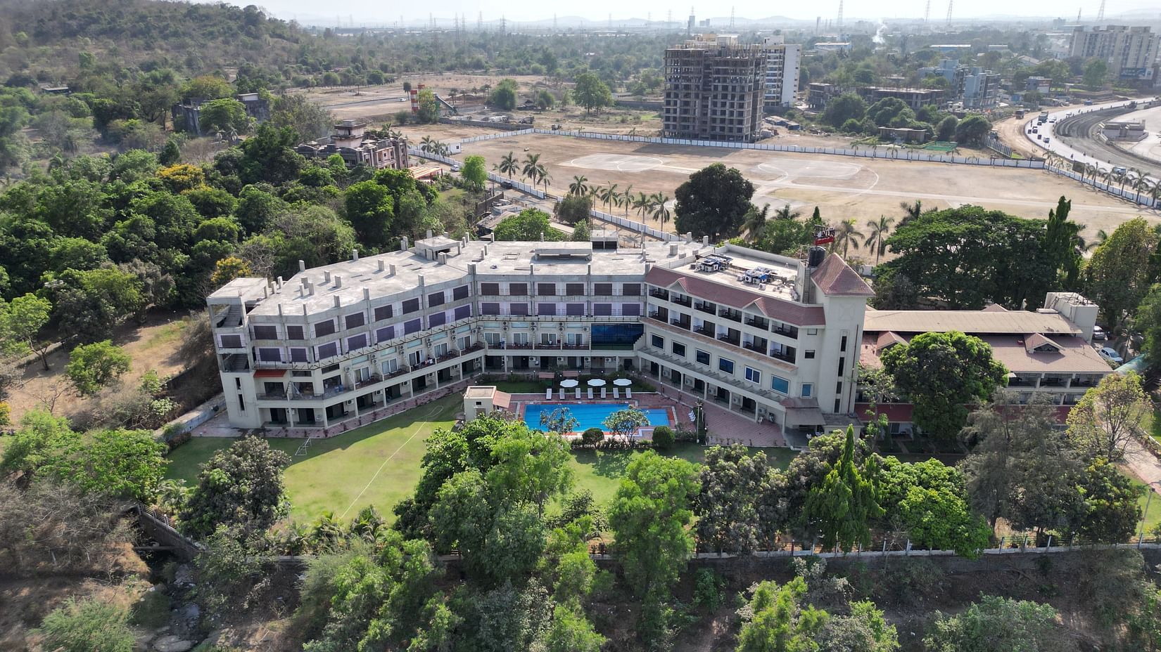 An aerial view of VITS Kamats Resort, Silvassa property surrounded by trees.