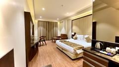 Deluxe Room with a huge bed and furniture at Pride Hotel Bhopal. 