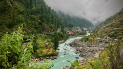 A stream flows amidst mountains and grass