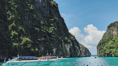 A boat travels across the Andaman sea and mountains are visible at the backdrop - Symphony Summer Sand Beach Resort and Spa