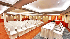 Banquet hall set up in theatre-style seating with white chairs and a head table at The Residency Karur, ideal for conferences and formal gatherings