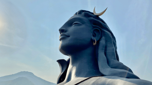 An overview of the statue of Adiyogi Shiva with a mountain in the background