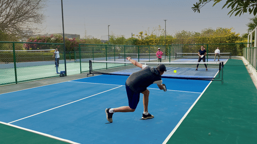 Two men enjoying the game of pickle ball at the sport junction of Karma Lakelands.