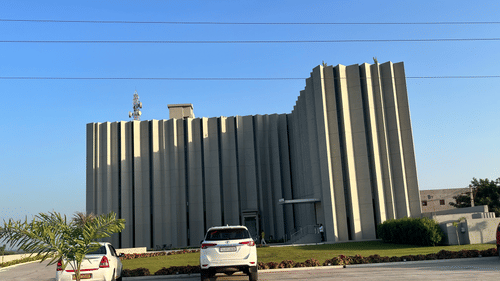 Facade with parking facilities at VITS Jamnagar under a clear sky with cars parked in front of the building