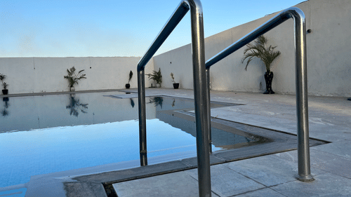 Iron railings of the swimming pool in Jamnagar at VITS Jamnagar, Mithoi, under a clear sky