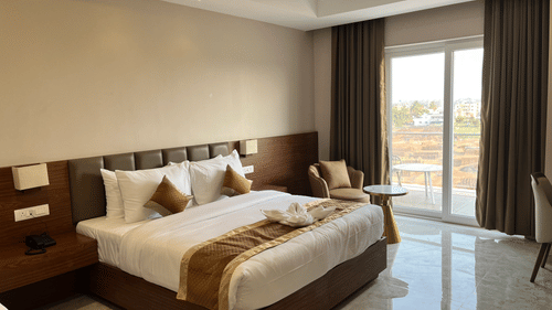 a bed at our room in VITS Satyajeet Karad overlooking the city through a window