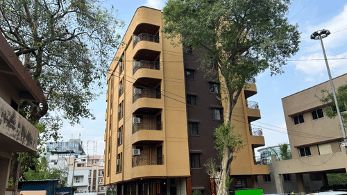 Another angle of the facade image of a building with a large tree in front at VITS Select Kharadi, Pune.