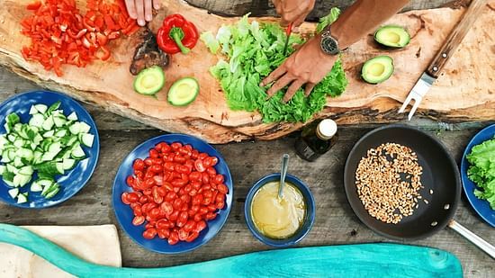 People preparing fresh vegetables and ingredients for a cooking class.