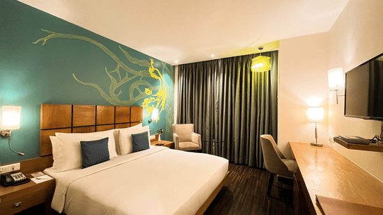 Deluxe Room at The Beatle Hotel, Powai, featuring a modern design with a peacock-themed wall mural.