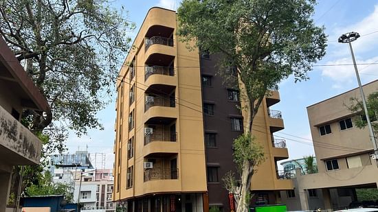 Another angle of the facade image of a building with a large tree in front at VITS Select Kharadi, Pune.