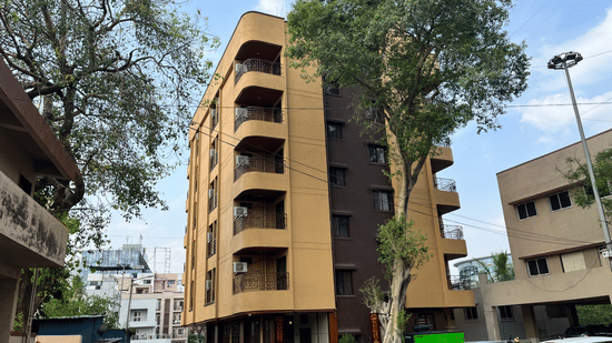 Another angle of the facade image of a building with a large tree in front at VITS Select Kharadi, Pune.