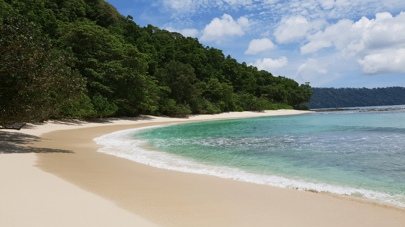 A view of a beach from seashore alongside a mountain | Barefoot at Havelock