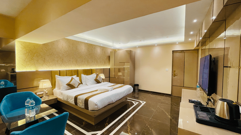 Another view of the king bed next to sofas inside Suite - Home2 Renaissance Club Hotel