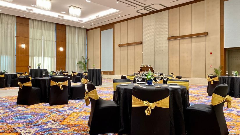 Round table seating inside the grand ballroom with lights shining down - karma lakelands.