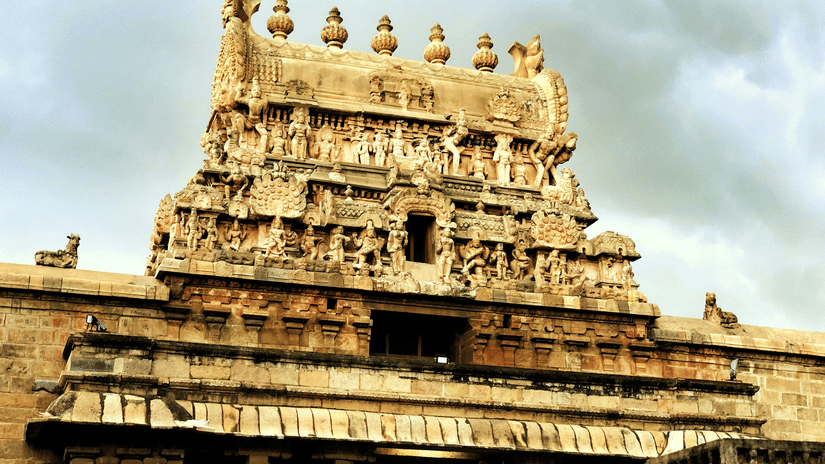 A facade view of Airavatesvara Temple, with intricate art on the roof of the temple, as seen during a cloudy day. This temple is one of the popular places to visit around Thanjavur for it's historical significance.