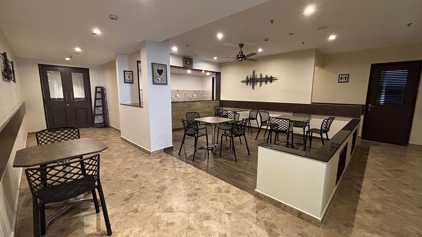 Dining seating at Gossip Corner with comfotable chairs around tables with modern decor. - Still Waters, Varkala