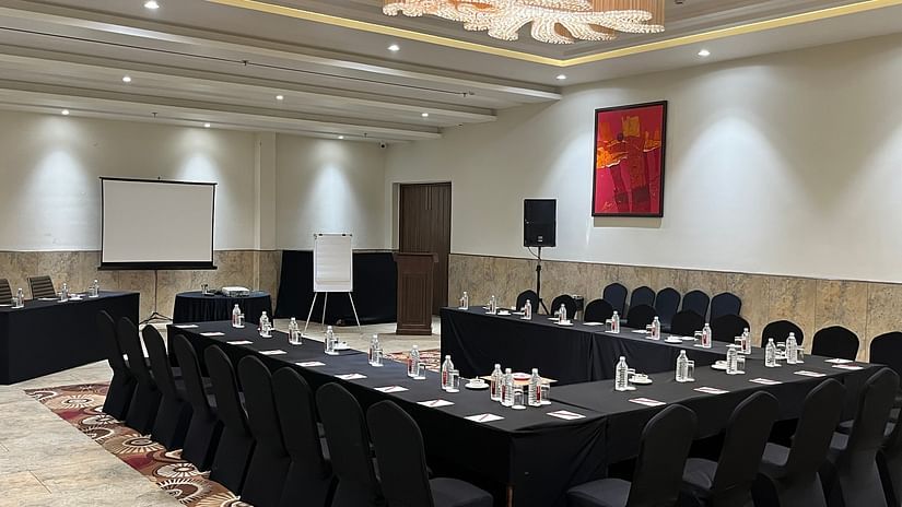 Conference hall with black chairs and projector at Lalita Grand 