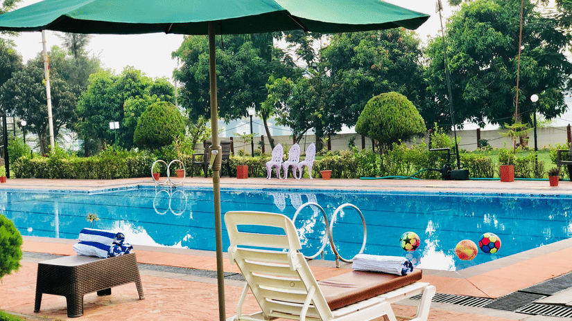 lounger under the canopy in front of the swimming pool - VITS Kamats Resort, Silvassa