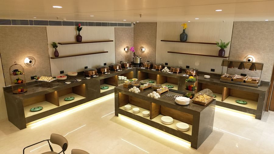 Dining space featuring neatly arranged racks with plates and cups at Clarks Collection Grand Sapphire, Ajmer.