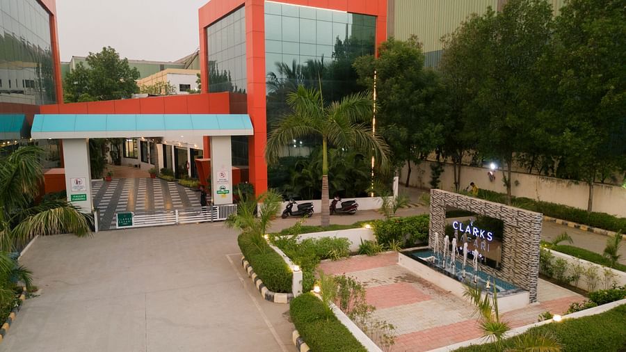 The view of Clarks Safari Kheda's entry, featuring its unique building design, well-maintained grounds, and a path leading up.